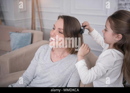 Pflege Mädchen ihre Mütter Haar kämmen Stockfoto
