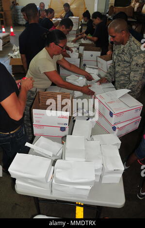 Das Emergency Family Assistance Center (EFAC) ist eine Notfallhilfe-Initiative der National Guard, die dazu dient, Angehörigen und Familien in Krisensituationen Hilfe zu leisten. Der 156. Luftbrücke operiert von der Muñiz Air National Guard Base in Puerto Rico. Ein archiviertes Bild dokumentiert Arbeiter und Flieger, die am 15. Oktober 2017 als Reaktion auf den Hurrikan Maria Impacts Vorräte vorbereiten und ausstellen. Stockfoto