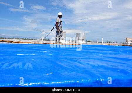 Mitglieder der 156 Tiefbau squadron Reparatur des Dachs durch Hurrikan Maria an der Muniz Air National Base, Puerto Rico beschädigt mit einer der weithin anerkannten FEMA blaue Blätter. (U.S. Air National Guard Foto vom Kapitän Matt Murphy) Stockfoto