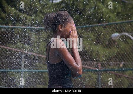 Juli 7, 2012 - Philadelphia, PA, USA: eine junge schwarze Frau kühlt sich in einem der öffentlichen Spray der Stadt gründen an einem heißen Sommertag. Stockfoto