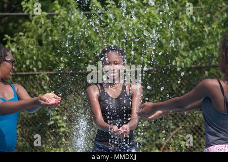 Juli 7, 2012 - Philadelphia, PA, USA: Drei junge schwarze Frauen erfrischen sich in einem der öffentlichen Spray der Stadt gründen an einem heißen Sommertag. Stockfoto