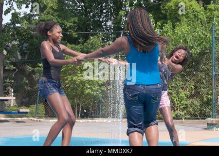 Juli 7, 2012 - Philadelphia, PA, USA: Drei junge schwarze Frauen erfrischen sich in einem der öffentlichen Spray der Stadt gründen an einem heißen Sommertag. Stockfoto