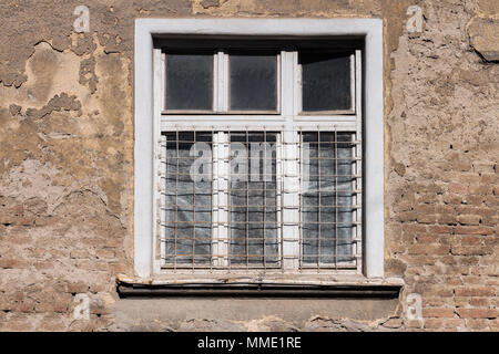 Alte weiß gerahmte Fenster auf einem alten, verfallenen Gebäude Stockfoto