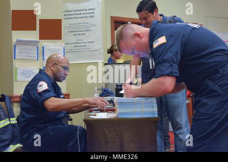 U.S. Coast Guard Chief Petty Officer Irwin Pascal, die Ressource Unit Leader, Kontrollen bei Respondern auf der Hurrikan Maria ESF-10 PR Unified Command Incident Command Post in San Juan, Puerto Rico, Okt. 20, 2017. Die Maria ESF-10 PR Unified Command, bestehend aus der Abteilung der natürlichen und ökologischen Ressourcen, der U.S. Coast Guard in Verbindung mit dem Puerto Rico Environmental Quality Control Board, Umweltschutz und der USA und Fish & Wildlife Service, reagiert auf Schiffe beschädigt werden, Vertriebene, in Wasser getaucht oder versunkenen. Das ESF 10 ist der Rahmen von Wh Stockfoto