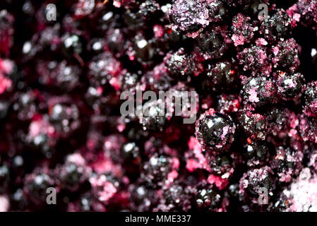 Schwarze Johannisbeere Konfitüre mit Zucker. Beeren Hintergrund. Ansicht von oben, in der Nähe Stockfoto