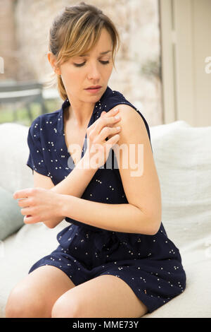 FRAU MIT SCHMERZEN IN DER SCHULTER Stockfoto