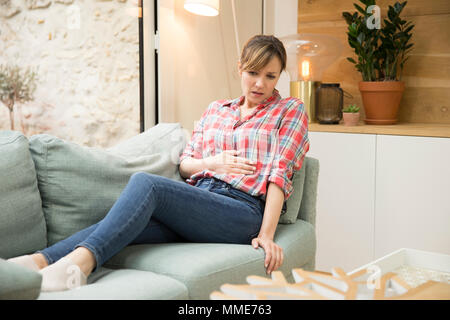 FRAU MIT SCHMERZEN IM UNTERLEIB Stockfoto