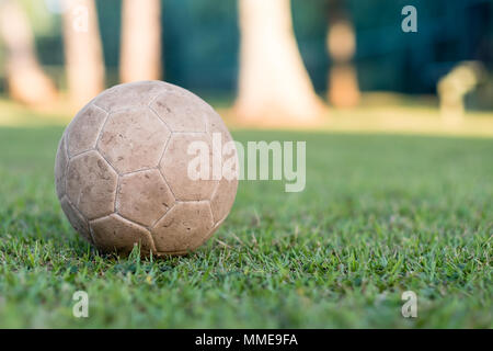 Vintage verwendet, Fußball, die auf dem Gras in Park, im Schatten. Bäume im Hintergrund sind in der Sonne, Rio de Janeiro Stockfoto