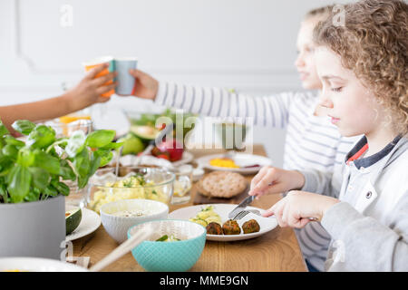 Junge Falafel essen während der Geburtstagsfeier zu Hause. Gesunde Ernährung für Kinder Stockfoto