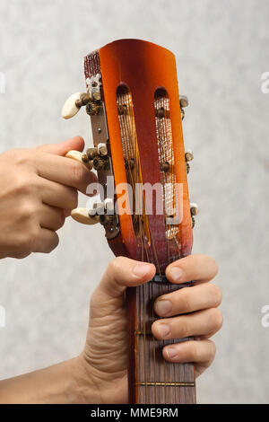 Nahaufnahme von Händen Stimmen akustischer Gitarre von kopfplatte Stockfoto