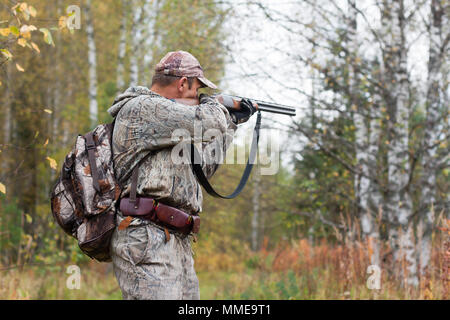 Hunter in der Tarnung Ziel von einem Jagd Gewehr im wildfowl Stockfoto