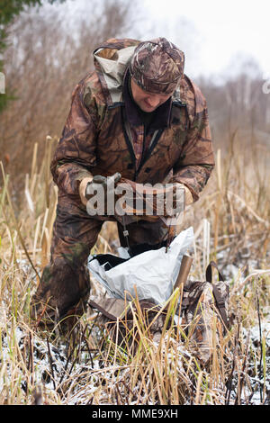 Hunter Vorbereitung Tellereisen für die Einstellung am Flussufer Stockfoto