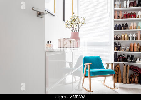Weiß Schränke in eleganten klassischen begehbarer Schrank mit Open Storage für Schuhe, Tür, blue Vintage Sessel und Pastelltönen gehalten Stockfoto