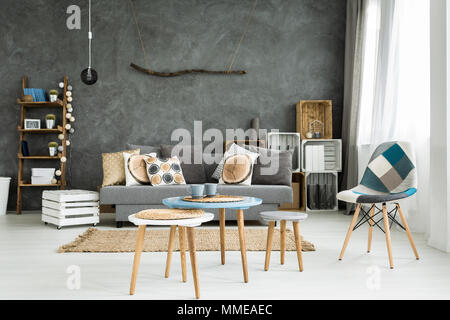 Moderne minimalistische und helles Wohnzimmer in den Farben Cyan mit Sofa mit Kissen, Stuhl, drei Tische, Teppich und Schlempe aus Woode Stockfoto