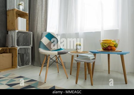 Moderne minimalistische Wohnzimmer Ecke mit Stuhl, drei Tische und Schlempe aus Holz Stockfoto