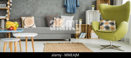 Panorama Foto von einem bunten Apartment mit einem grünen ei Sessel und Tische Stockfoto