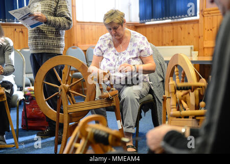 Spinner und Weber arbeiten an durchdrehende Räder, Garne zu den Shetland Wolle Woche Stockfoto