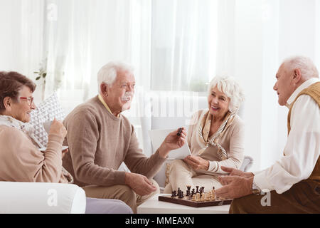 Gruppe von Happy Senioren Schach spielen zusammen Stockfoto