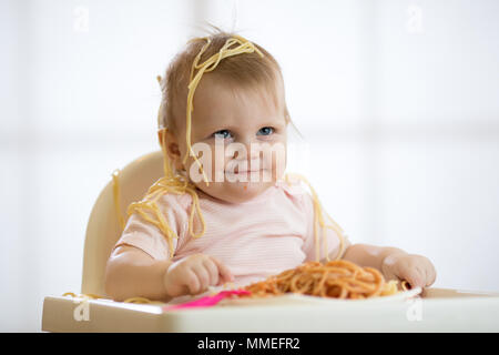 Baby essen Ihr Mittagessen und ein Chaos Stockfoto