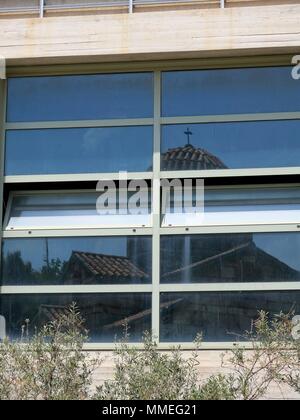 Spiegelung einer Kirche an einem Gebäudefenster. Stockfoto