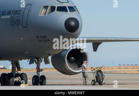 Ein US-Flieger steht neben einer KC-10 Extender auf der Rampe bei Travis Air Force Base, Calif., Okt. 21, 2017 geparkt. Mit rund 3.300 Flugzeuge ständig An- und Abreise auf monatlicher Basis, Travis AFB Griffe mehr Fracht- und Personenverkehr als jede andere militärische air terminal in den Vereinigten Staaten. (U.S. Air Force Foto von Heide Couch) Stockfoto