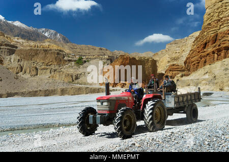 Loba Arbeiter Reisen auf einem Traktor entlang der trockenen Flussbett des Kali Gandaki River in der Nähe von Chele, Upper Mustang, Nepal. Stockfoto