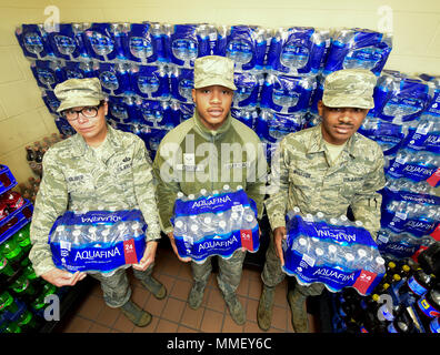 Flieger von 28 Force Support Squadron Raider Café Tragetaschen von Wasser bei Ellsworth Air Force Base, S.D., Okt. 24, 2017. Food Service Spezialisten geliefert 250 Fälle von Wasser mehr als 700 Piloten, die in der Base Schlafsäle, wenn eine Grenzlinie brach, so dass viele niedrige Bewohner unter einer blutgeschwürwassernachricht. (U.S. Air Force Foto von Airman 1st Class Randahl J. Jenson) Stockfoto