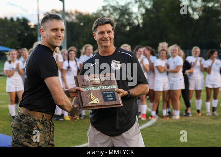 Sergeant Philip A. Blankenship, einem Recruiting Unterstation Murfreesboro Recruiter, gibt Fußball-Team der St. George's Girls' Trainer "Coaches Award" an der Richard Siegel Soccer Complex in Murfreesboro, Tennessee, Okt. 27, 2017. Seine Mannschaft gewann die Tennessee Girls' Soccer Meisterschaft für Abteilung II - A. Marines mit RSS Brentwood und RSS Murfreesboro herausgefordert, Weibchen mit einem kämpferischen Geist Marine Corps zu tun pullups an der Meisterschaft. (U.S. Marine Corps Foto von Sgt. Mandaline Limousine) Stockfoto