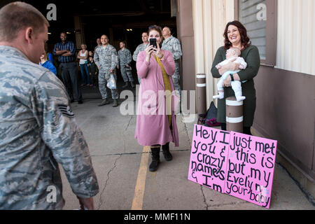 Staff Sgt. Derek Schmidt, 729 . Air Control Squadron, wird von seinem Ehepartner, Stephanie begrüßt und ihre 4 Monate alte Tochter, Evelyn, bei Hill Air Force Base, Arizona, Okt. 25, 2017. Schmidt, der nach Südwesten Asien in den letzten sechs Monaten eingesetzt worden war, traf seine Tochter in der Person für die erste Zeit. (U.S. Air Force Foto von Paul Holcomb) Stockfoto