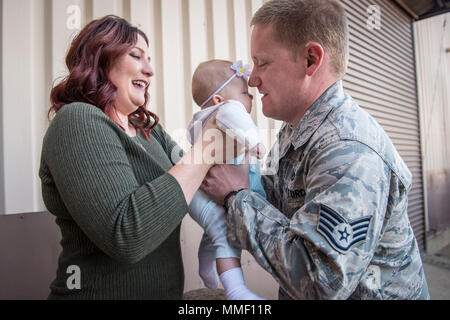 Staff Sgt. Derek Schmidt, 729 . Air Control Squadron, wird von seinem Ehepartner, Stephanie begrüßt und ihre 4 Monate alte Tochter, Evelyn, bei Hill Air Force Base, Arizona, Okt. 25, 2017. Schmidt, der nach Südwesten Asien in den letzten sechs Monaten eingesetzt worden war, traf seine Tochter in der Person für die erste Zeit. (U.S. Air Force Foto von Paul Holcomb) Stockfoto