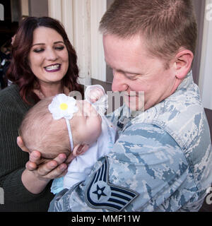 Staff Sgt. Derek Schmidt, 729 . Air Control Squadron, trifft seinen 4 Monate alten Tochter, Evelyn, in der Person zum ersten Mal auf der Hill Air Force Base in Utah, Oktober 25, 2017, während seine Frau, Stephanie, auf aussieht. Schmidt, zusammen mit 60 anderen 729 . ACS Flieger, gerade von einer 6-monatigen Einsatz in Südwestasien. (U.S. Air Force Foto von Paul Holcomb) Stockfoto