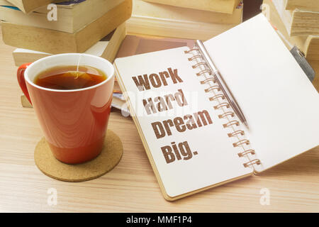 Harte Traum Arbeit groß. Inspirierende Angebot für Notizbuch mit Kugelschreiber, Tasse Tee und Stapel Bücher. Stockfoto