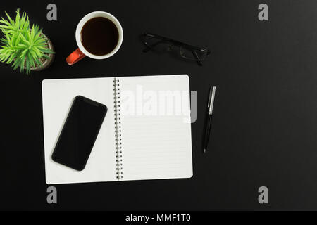 Arbeitsbereich tisch Schreibtisch mit Notebook, Smartphone, Stift, Kaffee, Brillen und Topfpflanzen. Ansicht von oben. Stockfoto
