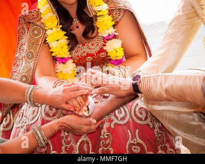 Die Hand der Braut von Bräutigam gehalten, während ein traditionelles Ritual in einem indischen Hindu-Hochzeit Stockfoto