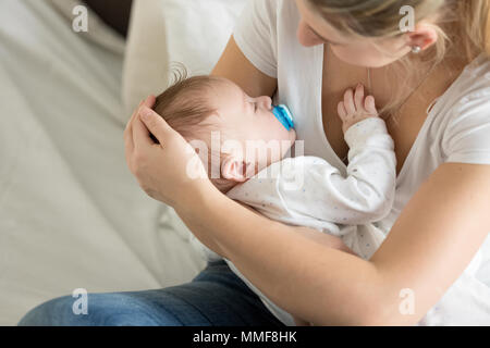 Nahaufnahme der jungen Mutter ihrem schlafenden Baby boy Streicheln Stockfoto