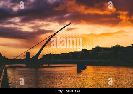 DUBLIN, Irland - Mai 9., 2018: Majestic orange und rosa getönten Sonnenuntergang über dem Fluss Liffey in Dublin, mit der Samuel Beckett Brücke Stockfoto