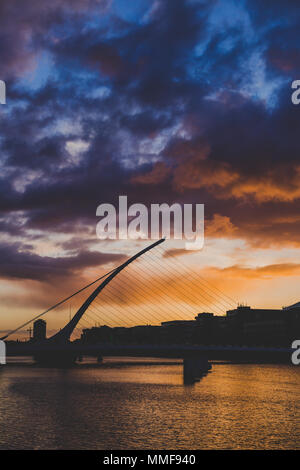 DUBLIN, Irland - Mai 9., 2018: Majestic orange und rosa getönten Sonnenuntergang über dem Fluss Liffey in Dublin, mit der Samuel Beckett Brücke Stockfoto