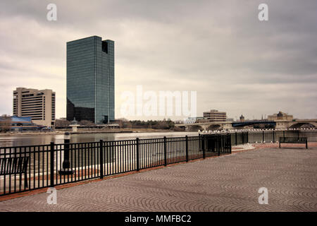 Einen Panoramablick über die Innenstadt von Toledo Ohio Skyline aus über dem Maumee River ein beliebtes Restaurant mit einem fertiger Backstein Boardwalk. Stockfoto