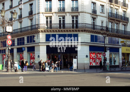 Anzeigen von Menschen zu Fuß auf der berühmten Einkaufsstraße Rue de Rivoli in Paris und berühmten amerikanischen Modeunternehmen speichern. Stockfoto