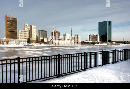 Ein Blick auf die Innenstadt von Toledo Ohio Skyline aus über die gefrorene und schneebedeckten Maumee River mit einem schönen Teilweise bewölkt blauer Himmel. Stockfoto