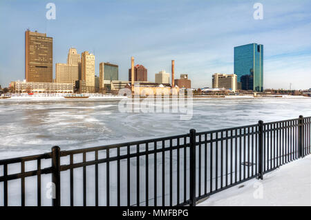 Ein Blick auf die Innenstadt von Toledo Ohio Skyline aus über die gefrorene und schneebedeckten Maumee River eine schöne leicht bewölkt blauer Himmel. Stockfoto