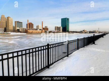 Ein Blick auf die Innenstadt von Toledo Ohio Skyline aus über die gefrorene und schneebedeckten Maumee River eine schöne leicht bewölkt blauer Himmel. Stockfoto