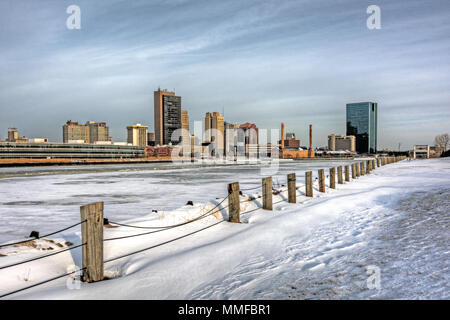 Ein Blick auf die Innenstadt von Toledo Ohio Skyline aus über die gefrorene und schneebedeckten Maumee River eine schöne leicht bewölkt blauer Himmel. Stockfoto