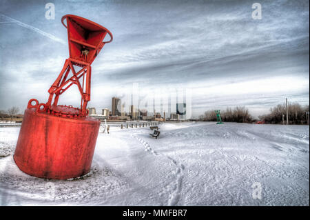 Ein Blick auf die Innenstadt von Toledo Ohio Skyline aus über die gefrorene und schneebedeckten Maumee River. Eine rote Boje sitzt im Vordergrund dieser Hafenstadt. Stockfoto
