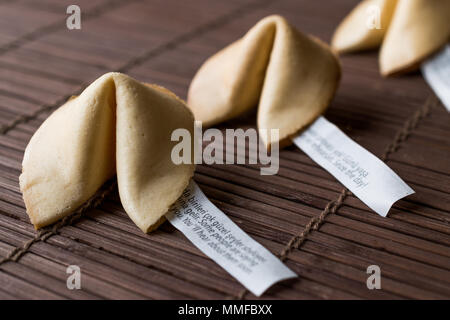 Chinesische Glückskekse auf Bambus Matte mit Stäbchen und Papier. Traditionelle Cookies Stockfoto