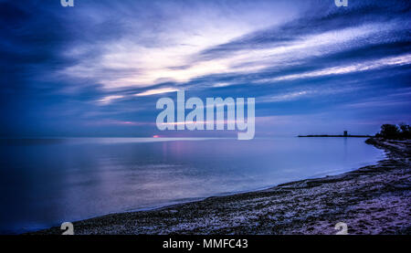 Schönen Pastelltönen Sonnenaufgang über Lake Erie von Magee Marsh im Nordwesten von Ohio. Davis-Besse Kernkraftwerk kann in der Ferne zu sehen ist. Stockfoto