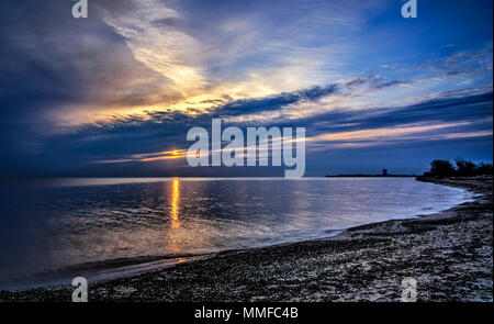 Schönen Sonnenaufgang über Lake Erie von Magee Marsh im Nordwesten von Ohio. Davis-Besse Kernkraftwerk kann in der Ferne zu sehen ist. Stockfoto