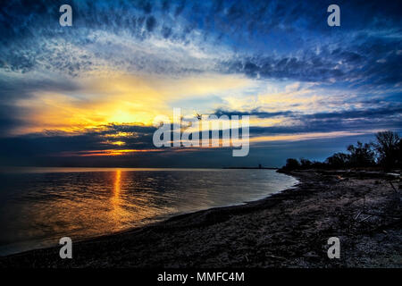 Schönen Sonnenaufgang über Lake Erie von Magee Marsh im Nordwesten von Ohio. Davis-Besse Kernkraftwerk kann in der Ferne zu sehen ist. Stockfoto