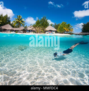 Mann Schwimmen in einer tropischen Lagune vor exotischen Insel Stockfoto