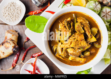 Thai Food: Die eingeweide von Makrele fisch Bauch hot spicy Curry oder Fisch Organe saure Suppe mit Gemüse auf Holztisch, Thai Sprache ist Kang Tai Pla Stockfoto